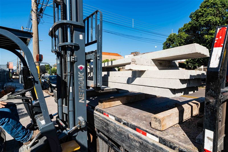 Empilhadeira carregando mourões de concreto para entrega na JBR