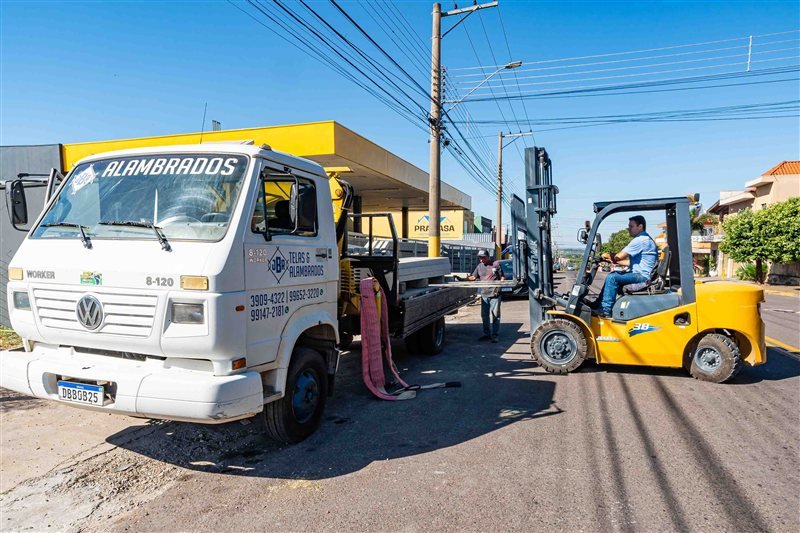 Caminhão de entrega JBR Telas e Alambrados e empilhadeira no pátio